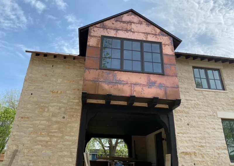 Copper metal panel facade on a stone building for Skylight Installation in Pelican Bay